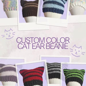 May include: A collection of ten crocheted cat ear beanies in various colors, including pink, blue, brown, purple, red, gray, and green. The beanies are displayed on white mannequins against a purple background. The text "CUSTOM COLOR CAT EAR BEANIE" is displayed in the center of the image.
