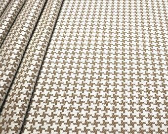 May include: Brown and white houndstooth fabric with a subtle texture. The fabric is folded in a few places, showing the pattern from different angles.
