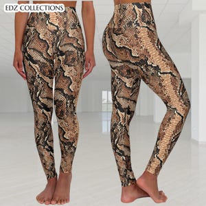 Pode incluir: Leggings de cintura alta com padrão de pele de cobra em tons de castanho, bege e preto. Os leggings são justos e apresentam o texto "EDZ COLLECTIONS" no topo.