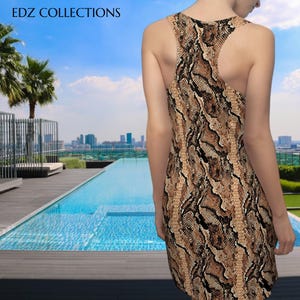 Könnte beinhalten: Ärmelloses Kleid mit Schlangenmuster in Braun-, Beige- und Schwarztönen. Das Kleid hat ein Racerback-Design. Der Text "EDZ COLLECTIONS" ist oben im Bild zu sehen. Der Hintergrund umfasst einen Pool und eine Skyline.