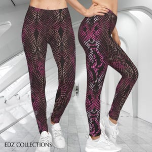 Könnte beinhalten: Leggings mit Schlangenmuster in Schwarz, Pink und Beige. Die Leggings sind figurbetont und haben eine hohe Taille. Der Text "EDZ COLLECTIONS" ist unten links sichtbar. Das Model trägt weiße Turnschuhe.
