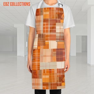Pode incluir: Um avental com um design de patchwork em tons de laranja, castanho e creme. O avental apresenta uma mistura de quadrados xadrez e lisos, criando um visual texturizado. O texto "EDZ COLLECTIONS" é visível no topo.