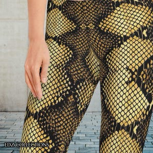 May include: Leggings with a snakeskin pattern in shades of gold and black. The leggings have a detailed scale design, creating a realistic reptile skin effect. The text "EDZ COLLECTIONS" is visible at the bottom.
