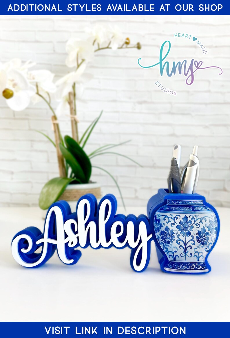 May include: Blue and white personalized desk organizer with the name "Ashley" in white lettering. The organizer features a blue and white porcelain design with floral patterns. The organizer is a great way to keep your desk tidy and organized.