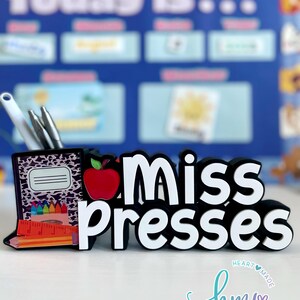 May include: Black and white desk organizer with a leopard print design. The organizer has a red apple, pencils, and a ruler. The text "Miss Presses" is in white letters on a black background.
