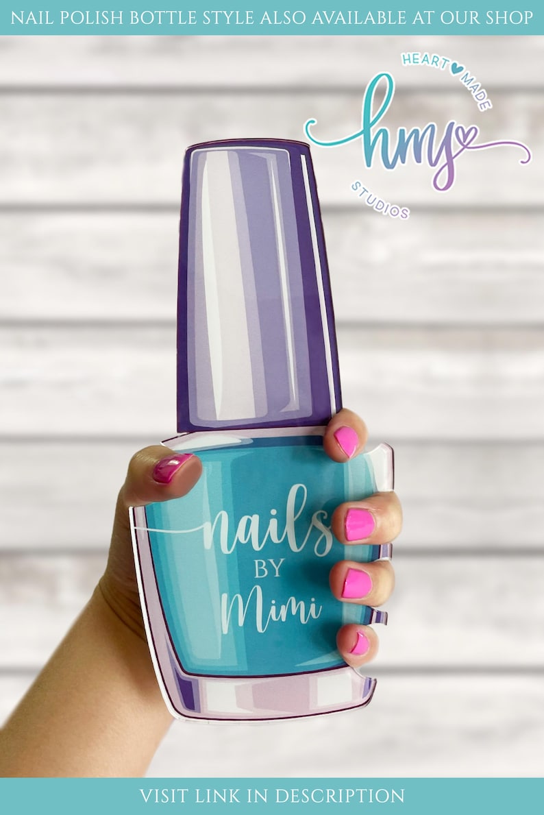 May include: A blue and purple nail polish bottle with the text "nails by Mimi" on the front. The bottle is being held by a hand with pink nail polish.