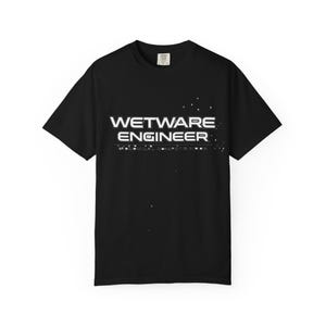 Puede incluir: Camiseta negra con el texto blanco "WETWARE ENGINEER" en una fuente futurista. La camiseta tiene mangas cortas y cuello redondo. El texto está centrado en el pecho.