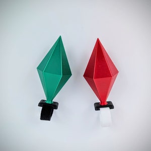 May include: Two 3D printed diamond-shaped ornaments, one green and one red, with black bases and velcro straps.