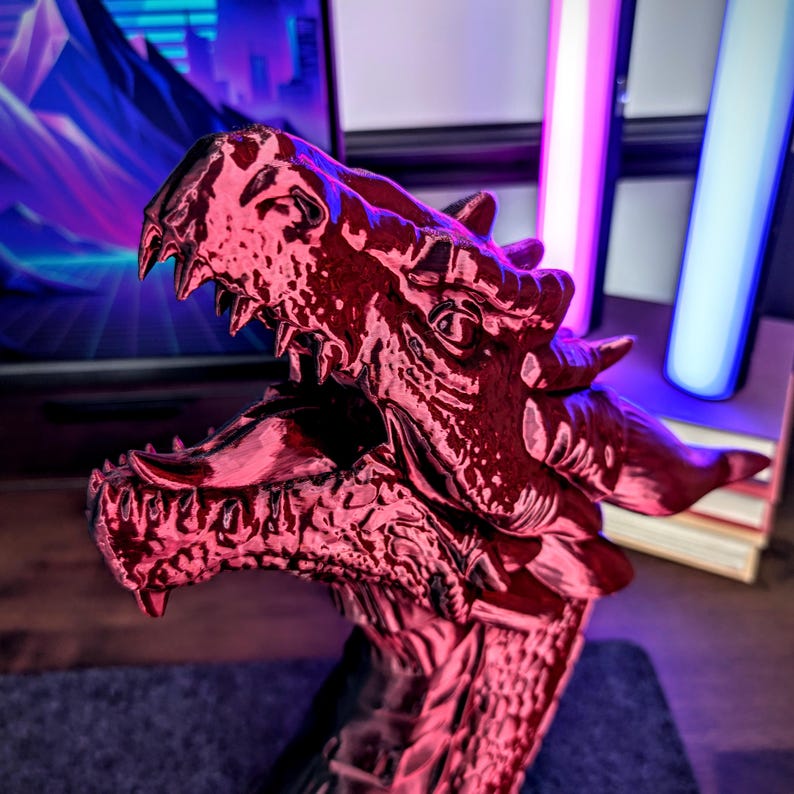 May include: A detailed, red dragon head sculpture with open jaws, sharp teeth, and textured scales. The dragon's head is the focal point, showcasing intricate details and a menacing expression. The sculpture is likely a decorative item or a collectible.