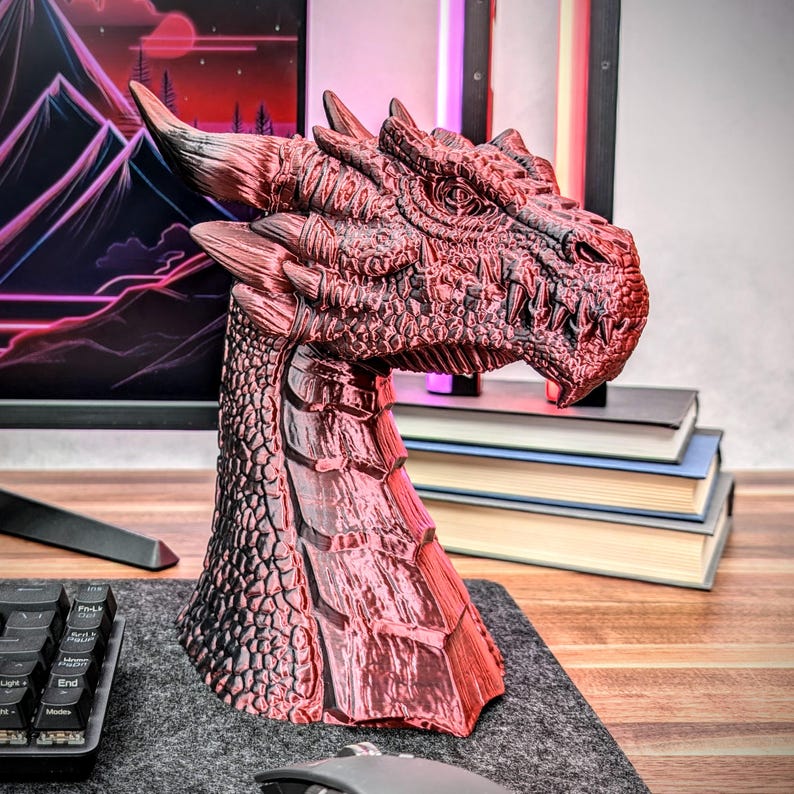 May include: A red and black dragon head sculpture with a detailed textured surface. The sculpture is made of a shiny material and has a fierce expression.