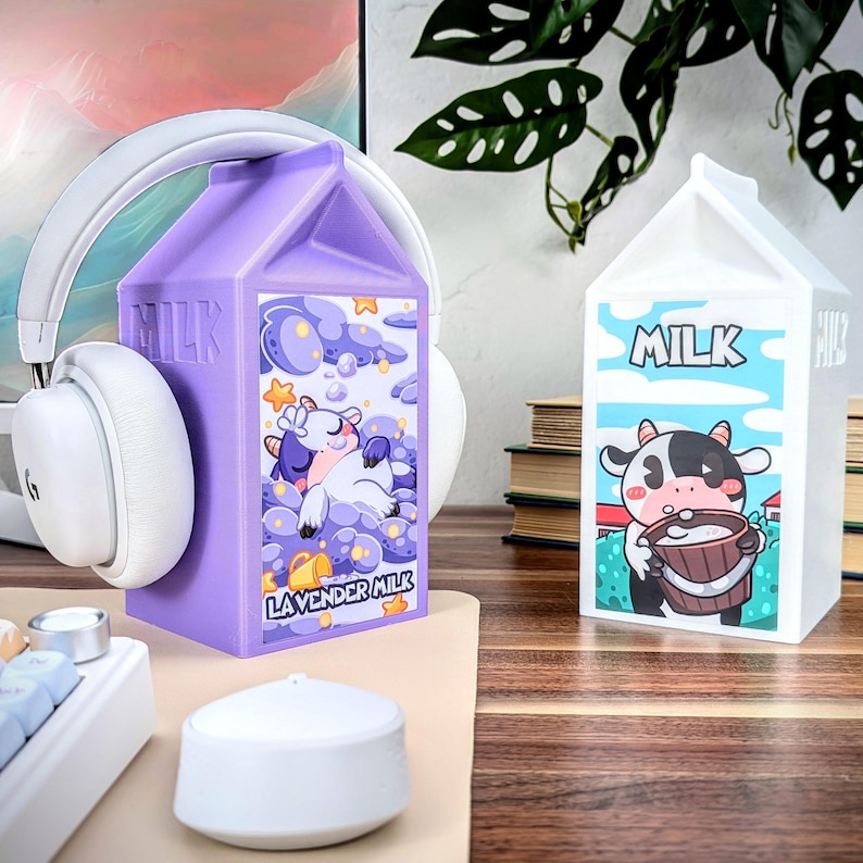 May include: Two milk carton shaped containers, one purple with a sleeping cow and the text "Lavender Milk" and the other white with a cow drinking milk and the text "Milk".
