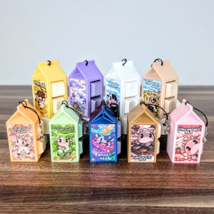 May include: A set of ten mini milk carton shaped stackable toys. Each carton features a different flavour of milk, including strawberry, chocolate, matcha latte, peach and cream, space milk, oat milk, and regular milk. Each carton has a cute cartoon cow on the front.