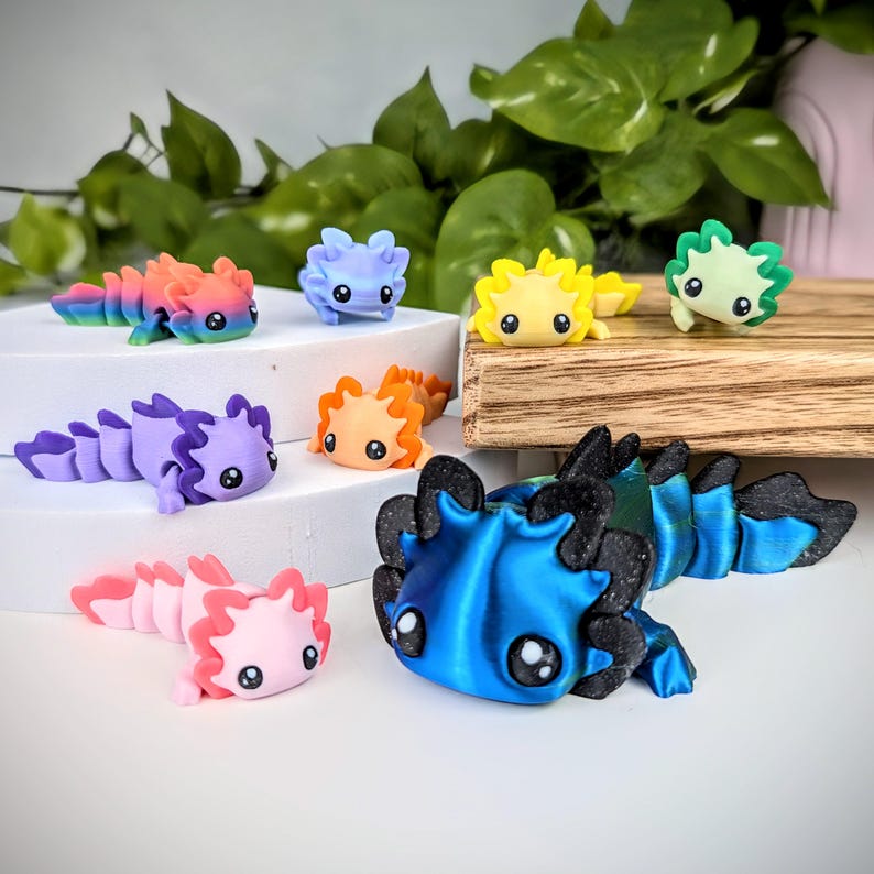 May include: A collection of eight hand-painted axolotl figurines. The figurines are made of polymer clay and come in a variety of colors, including pink, blue, green, yellow, orange, and purple. Each figurine has a unique design and features a cute, cartoon-like face.