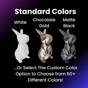 May include: Three geometric rabbit figurines in white, gold, and black. The text "Standard Colors" is above the figurines. The text "White", "Chocolate Gold", and "Matte Black" are below the figurines. The text "...Or Select The Custom Color Option to Choose from 50+ Different Colors!" is below the figurines.