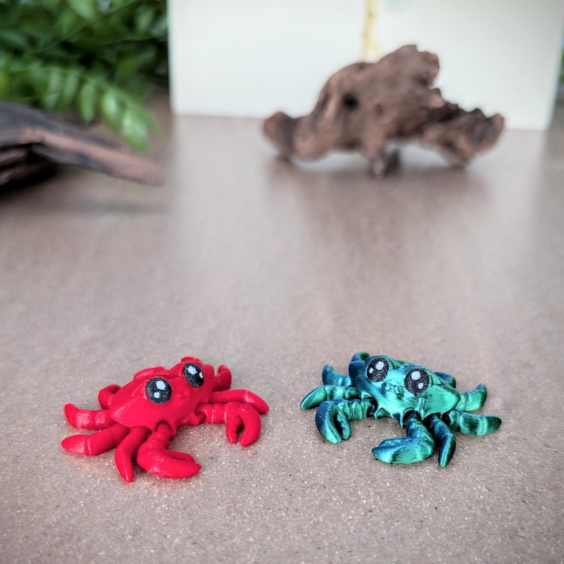 May include: Two small, hand-painted, ceramic crabs. One crab is red with black eyes and the other is green with black eyes.