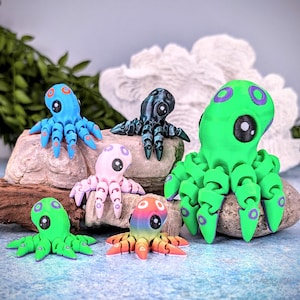 May include: Six colorful octopus figurines with different colored eyes and bodies. The octopus figurines are made of plastic and are about 2 inches tall.