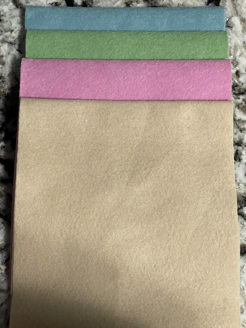 Puede incluir: Cuatro hojas de fieltro en colores pastel: azul claro, verde, rosa y beige. Las hojas de fieltro est&aacute;n apiladas, mostrando los diferentes colores y texturas. Ideal para proyectos de manualidades.