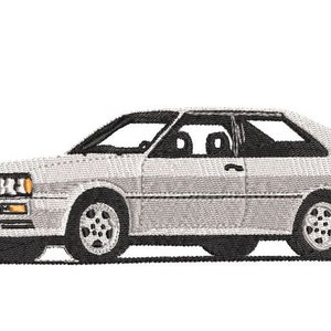 May include: A white Audi Quattro Coupe with black trim and black wheels. The car is a classic sports car with a sleek design.