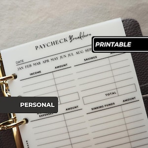 Könnte beinhalten: Ein durchscheinender Planer-Einsatz aus Kunststoff mit der Überschrift PAYCHECK Breakdown und schwarzem Aufdruck. Das Layout enthält Abschnitte für Datum, Einkommen, Ersparnisse, Ausgaben und Rücklagen mit Spalten für Beträge.