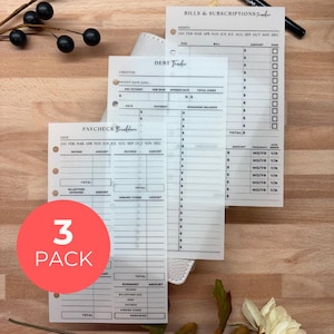 May include: Three-pack of financial planner inserts. The inserts include a debt tracker, a paycheck breakdown, and a bills and subscriptions tracker. The inserts are white with black text and are designed to be used with a binder.