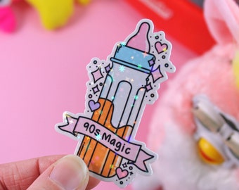 Pode incluir: Um adesivo holográfico com uma mamadeira rosa e azul com um lápis amarelo dentro. O adesivo tem uma faixa rosa com o texto "90s Magic" em branco.