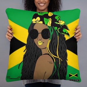 Pode incluir: Uma almofada verde, amarela e preta com um desenho de uma mulher com longos dreadlocks negros usando óculos de sol e uma bandana com flores. A mulher está olhando por cima do ombro. A almofada tem as palavras "Jamaica" e "Tamaral C" impressas nela.