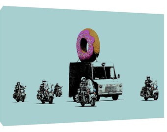 May include: A white van with a large pink and brown donut on top, followed by a line of five police officers on motorcycles. The officers are wearing black helmets and jackets, and the motorcycles are black.