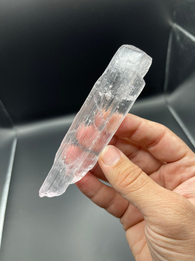 May include: A translucent white selenite crystal wand with a smooth, polished surface. The wand has a natural, raw edge and is approximately 5 inches long.