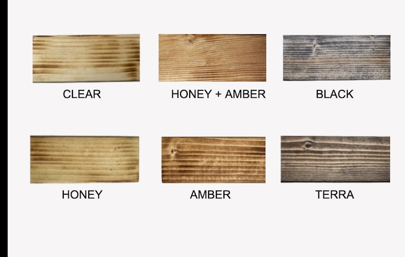 May include: A collection of six wooden planks, each showcasing a different stain color. The colors include Clear, Honey + Amber, Black, Honey, Amber, and Terra. The planks are rectangular and display the wood grain.