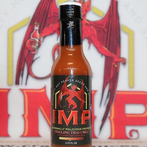 Puede incluir: Una botella de salsa picante de 5,75 onzas líquidas con una etiqueta roja que presenta un duende de dibujos animados y el texto "Internally Malicious Peppers Tingling Thai Chili".