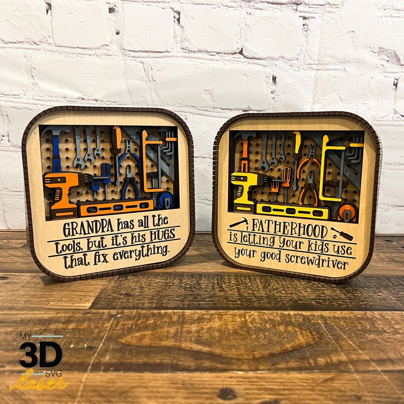 May include: Two wooden signs with a 3D design of tools. The sign on the left says "GRANDPA has all the tools, but it's his HUGS that fix everything." The sign on the right says "FATHERHOOD is letting your kids use your good screwdriver."