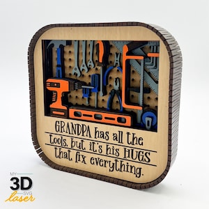 May include: A wooden sign with a cutout of a tool rack. The sign says "GRANDPA has all the tools, but it's his HUGS that fix everything."