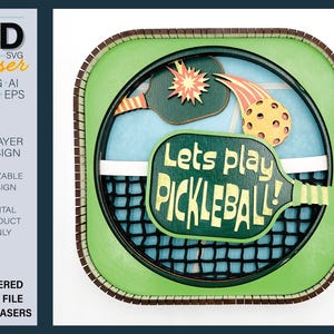 May include: A 6-layer, 3D laser cut design of a pickleball paddle with the text "Lets play pickleball!" in green and yellow. The design is framed in a green and brown border.