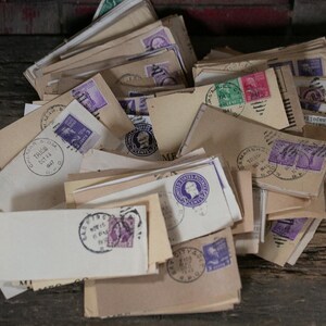 May include: A pile of vintage envelopes in various sizes and shades of tan and cream. The envelopes are adorned with purple, green, and pink postage stamps and circular postmarks. The image evokes a sense of nostalgia and history.