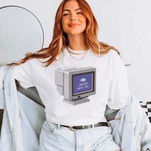 Può includere: Felpa bianca con una grafica di uno schermo di computer che dice "Brain says no." Lo schermo è blu e ha una piccola icona di cervello nell'angolo in alto a sinistra.