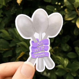 May include: A sticker with three silver spoons tied together with a purple ribbon that says "ALL OUT OF SPOONS".