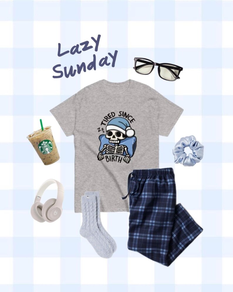 May include: A gray t-shirt with a skeleton wearing a Santa hat and the text "Tired Since Birth". The outfit also includes blue and white plaid pajama pants, a pair of gray socks, a light blue hair scrunchie, a pair of black glasses, and a white cup of coffee.