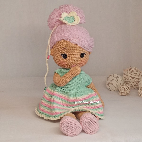 modèle de poupée au crochet pdf Adele, avec des cheveux bouclés roses, une robe en tricot et des chaussures au crochet