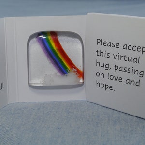 May include: A small white box with a pull tab. The box contains a glass paperweight with a rainbow inside. The box has the text "Please accept this virtual hug, passing on love and hope." printed on it.