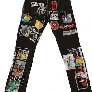 May include: Dark green cargo pants with various patches sewn on, including cartoon characters, band logos, and graphic designs. The patches include "Cartoon Network", "死神", "MAXE", "AKIRA", "GANTZ 1", "OLDBOY", and "I AM A HERO".