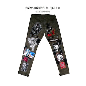 May include: Green cargo pants with various patches, including a gun, angel wings, a demon, and a butterfly. The pants have the text "SOSMULA'S PAIR EXCLUSIVE" printed on the waistband.