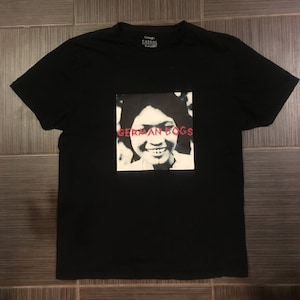 Puede incluir: Camiseta negra con un estampado gráfico de la cara de una mujer con el texto "GERMAN DOGS" en rojo.
