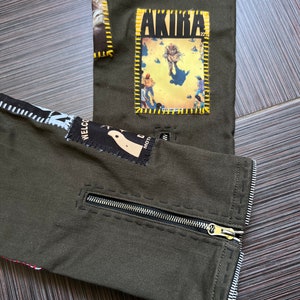 May include: Green pants with a zipper on the side and various patches sewn on, including one with the word "AKIRA" on it.