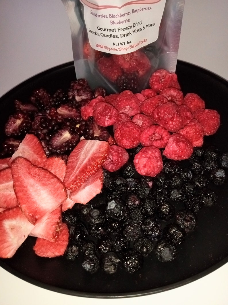 Pu&ograve; includere: Un piatto nero con una variet&agrave; di frutta liofilizzata, tra cui fragole, lamponi, more e mirtilli. Il testo sulla busta recita "Gourmet Freeze Dried Snacks, Candies, Drink Mixes & More. Net WT 1 oz. www.Etsy.com/Shop/OutlawFoodie"