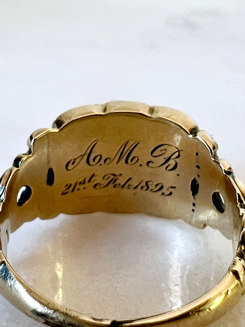 May include: A gold ring with an inscription that reads "A.M.B. 21st Feb. 1892".