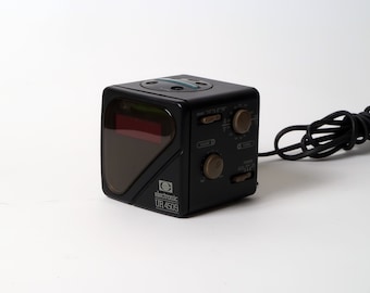 Könnte beinhalten: Ein schwarzer elektronischer Radiowecker mit roter Digitalanzeige und braunen Knöpfen. Der Radiowecker hat ein Netzkabel und den Text "electronic UR 4509" auf der Vorderseite.