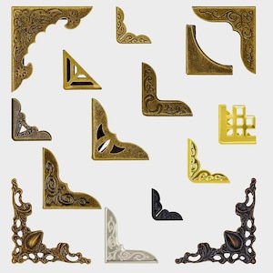 May include: An assortment of decorative metal corner brackets in various shapes and finishes, including gold, bronze, silver, and black. The brackets feature ornate, vintage-inspired designs, suitable for crafting or home decor projects.