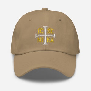 May include: A khaki baseball cap with a white embroidered cross and the text "IC XC NI KA" in gold.