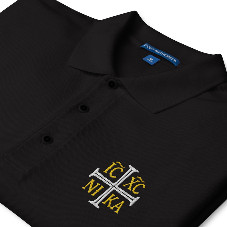 May include: Black polo shirt with a white cross and the text "IC XC NIKA" embroidered in gold.