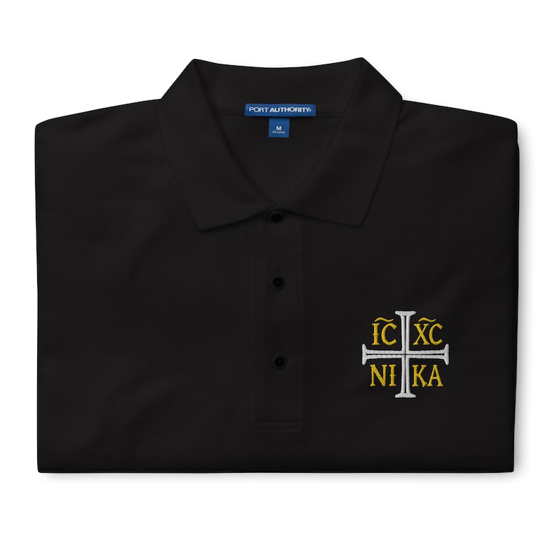 May include: Black polo shirt with a white embroidered cross and the text "IC XC NI KA" in gold lettering.